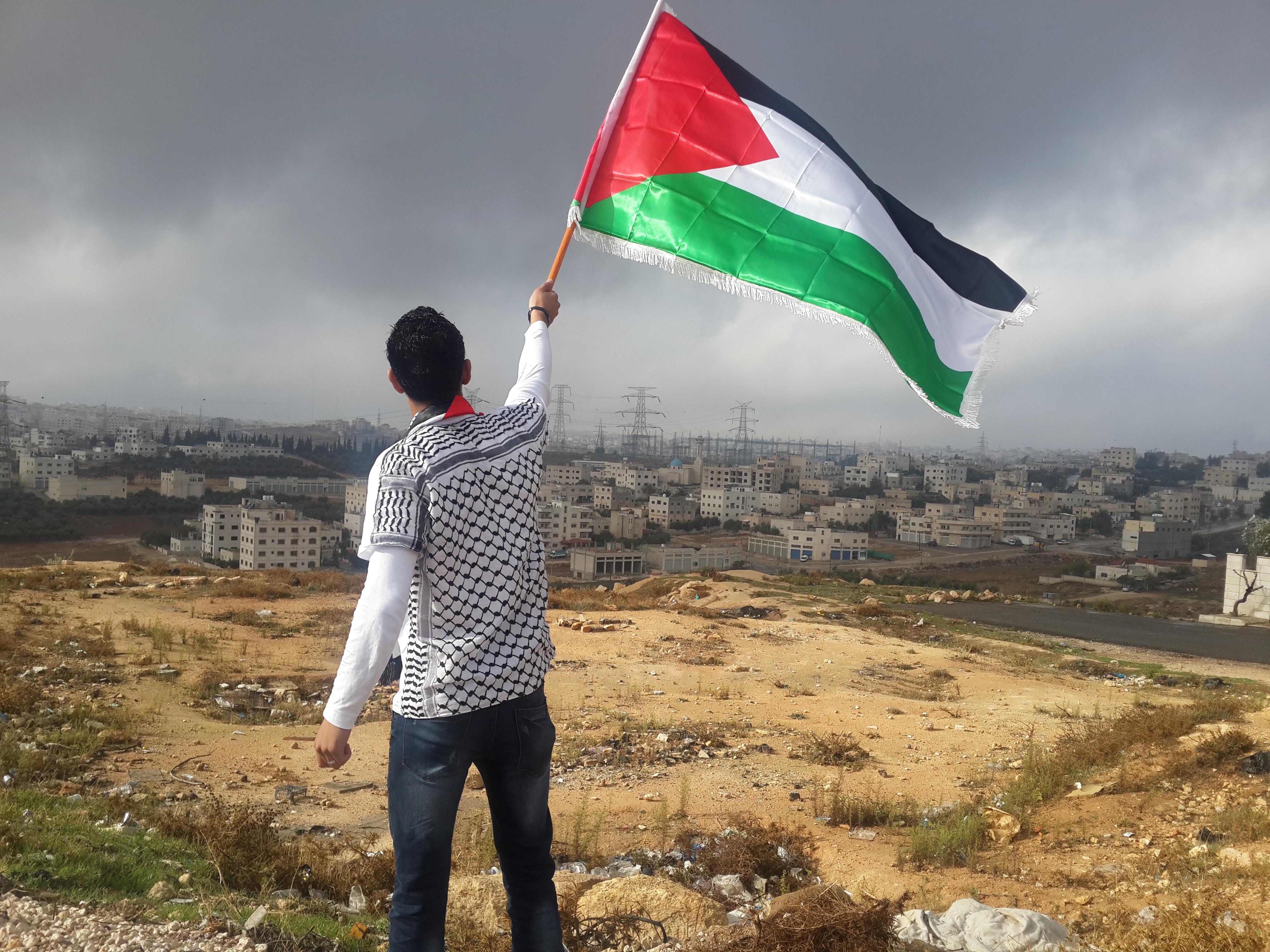 man waving palestine flag in gaza